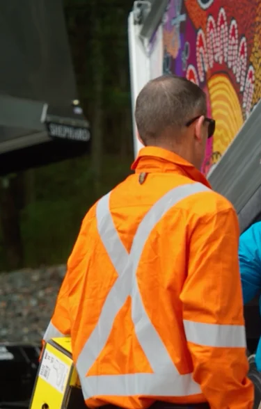 Nathan Turner from True Blue Transport Group speaking with a worker in high-visibility clothing beside a Holcim-branded truck.