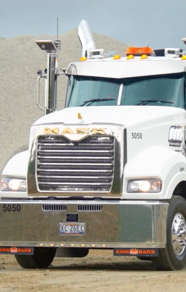 Holcim-branded Mack heavy haulage truck and trailer with Indigenous artwork design, parked on a gravel site in Queensland.