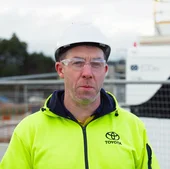 Joel Driscoll from Toyota, wearing high-vis and a hard hat, on site at Melbourne Airport.