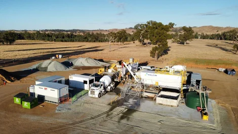 Aerial view of a Holcim mobile concrete batching plant on a cleared rural site.