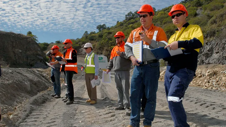 Workers in personal protective equipment observing a blast at Beenleigh Quarry