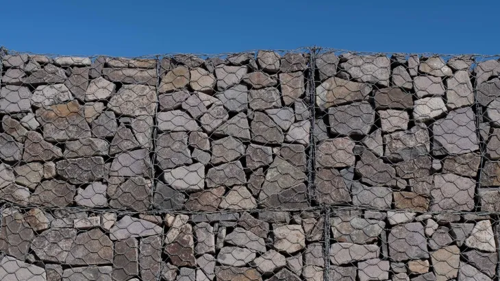 Large gabion wall detail on a sunny day against a clear blue sky